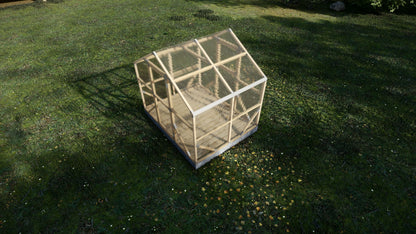 Small wooden greenhouse on a grassy field
